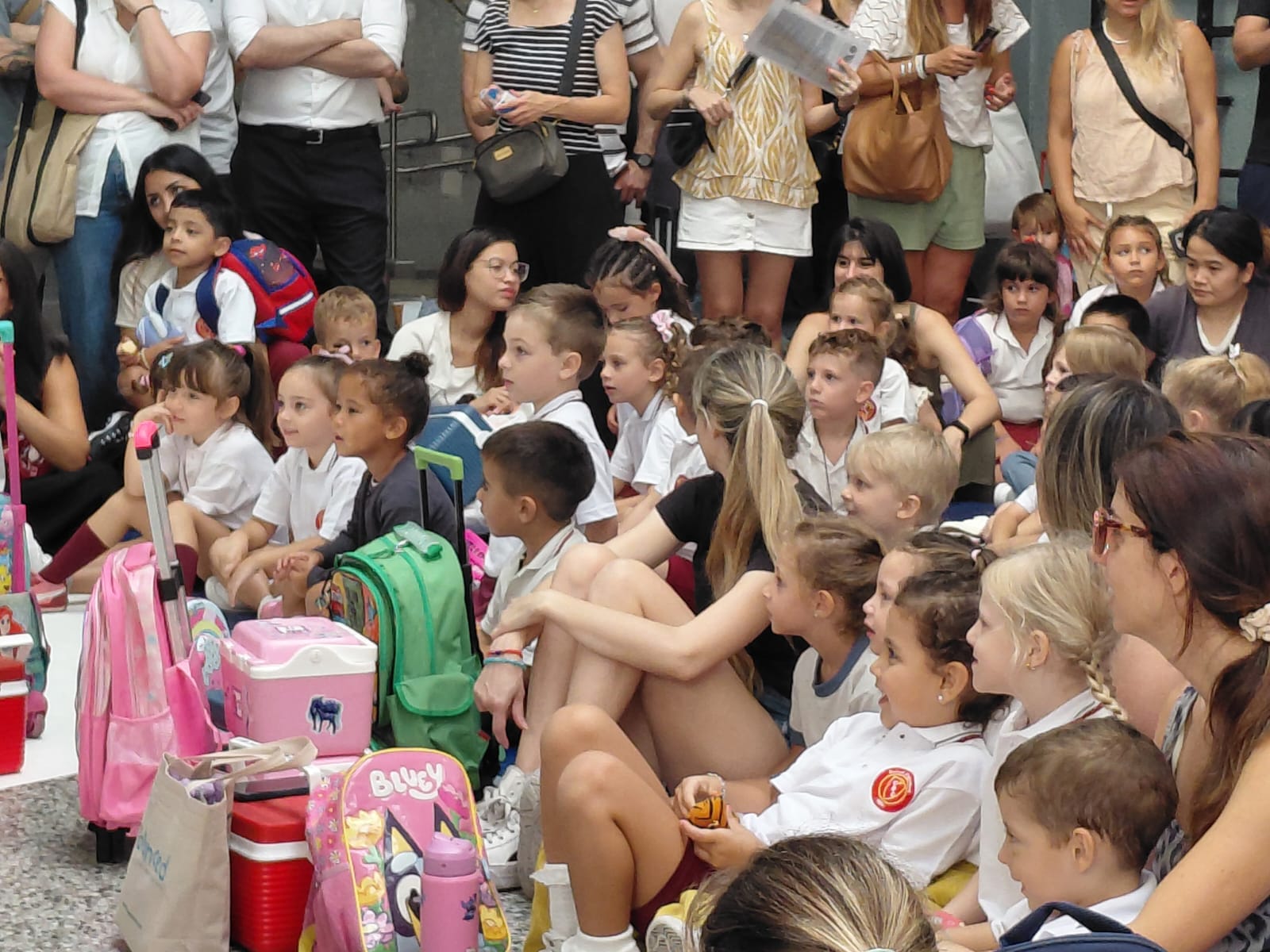 Niños y niñas explorando el espacio escolar durante una actividad grupal
